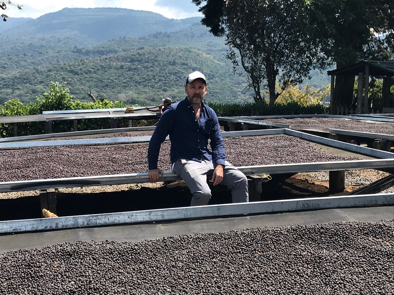 Ralf sitting with beans in a farm