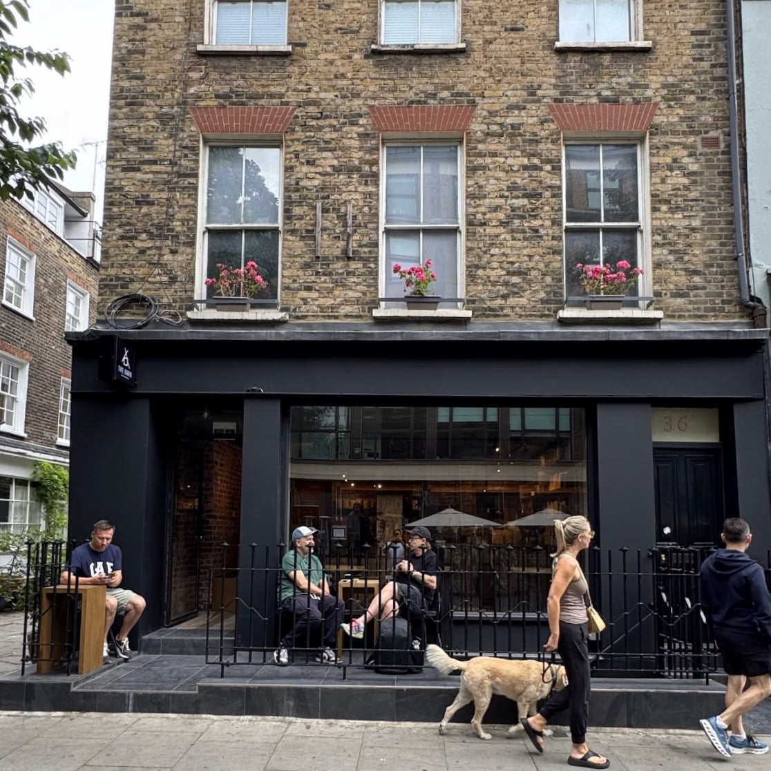 Exterior view of THE BARN London with customers enjoying terrace.